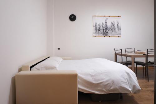 1 dormitorio con 1 cama y 1 mesa con sillas en Bonomelli Home con posto auto Fondazione Prada en Milán