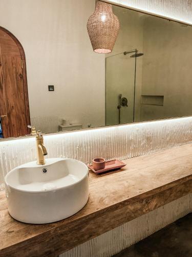 a bathroom with a sink and a mirror at AMMA Boutique Hotel in Ahangama