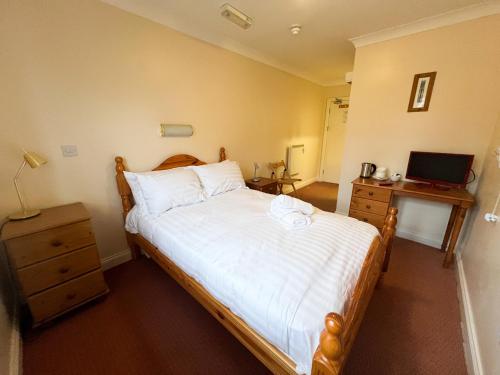 a bedroom with a bed and a desk with a laptop at The Exchange Hotel in Brigg