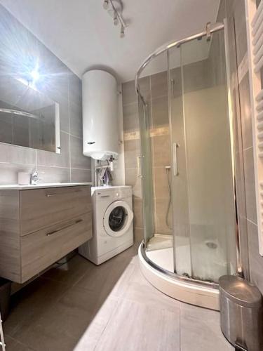 Appartement F3, 2 chambres في إيفري سور سين: حمام مع دش وغسالة ملابس