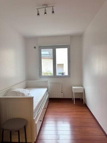 Appartement F3, 2 chambres في إيفري سور سين: غرفة بيضاء مع سرير ونافذة