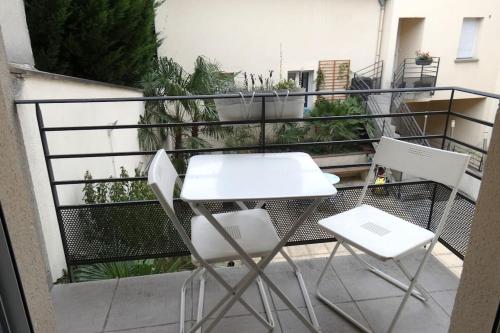 a white table and two chairs on a balcony at Appartement F3, 2 chambres in Ivry-sur-Seine