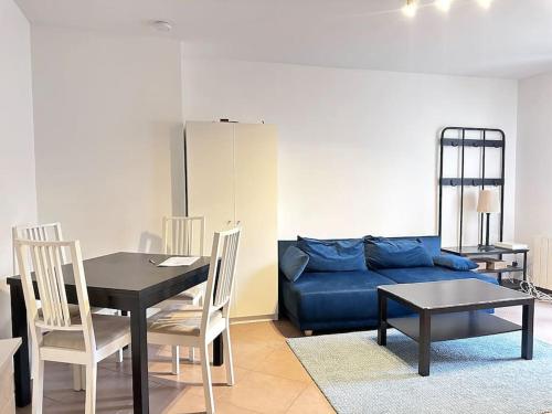 Appartement F3, 2 chambres في إيفري سور سين: غرفة معيشة مع أريكة زرقاء وطاولة
