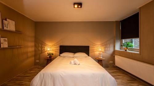 a bedroom with a large white bed with two pillows at Stadsappartement Franeker 9 in Franeker