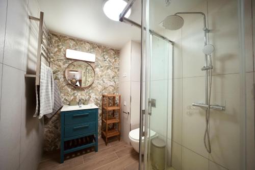 a bathroom with a blue sink and a shower at Parsami Suites in Santa Pola