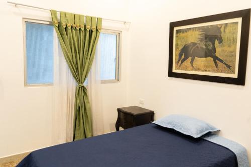 a bedroom with a bed and a picture of a horse at HOTEL GANADERO in La Dorada