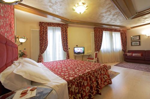 Habitación de hotel con cama y TV en Hotel Luis en Fiera di Primiero