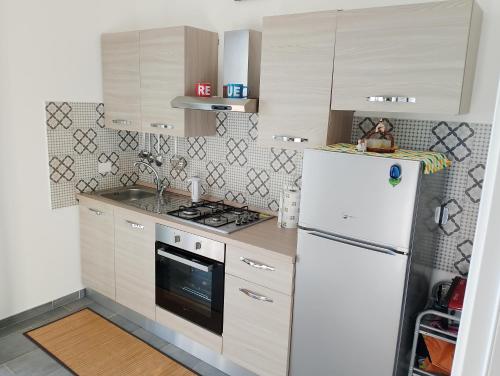 eine Küche mit einem weißen Kühlschrank und einem Herd in der Unterkunft Incantevole appartamento tra Portofino e le 5 Terre in Chiavari