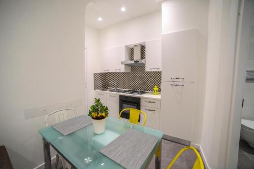 eine Küche mit einem grünen Tisch und gelben Stühlen in der Unterkunft Scugnizzo Apartment in Neapel