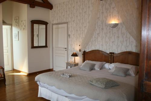 a bedroom with a large bed with a wooden headboard at La Closerie des Sacres in Lavannes