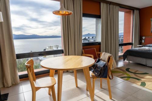 a room with a table and chairs and a large window at Belgrano Decks II in San Carlos de Bariloche