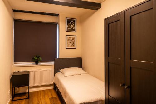 niewielka sypialnia z łóżkiem i oknem w obiekcie Stadsappartement Franeker 11 w mieście Franeker