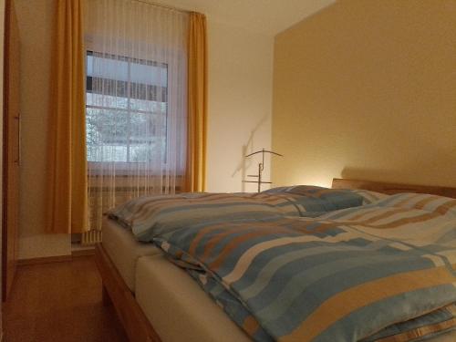 a bed sitting in a bedroom with a window at Fuchs in Eslohe