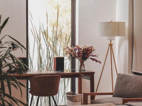 a desk with a vase of flowers and a lamp at Cuna del Cielo in San Miguel de Allende