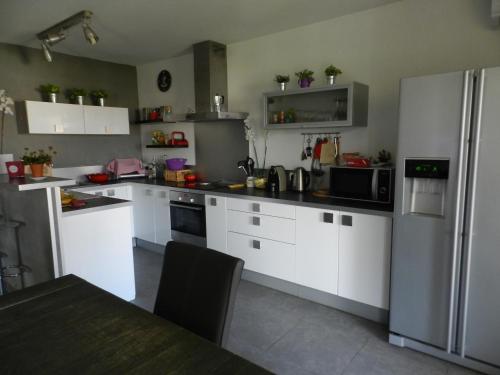  La cuisine est équipée de placards blancs et d'un réfrigérateur. dans l'établissement Appartement à 5mn à pied des plages, à LʼÎle-Rousse