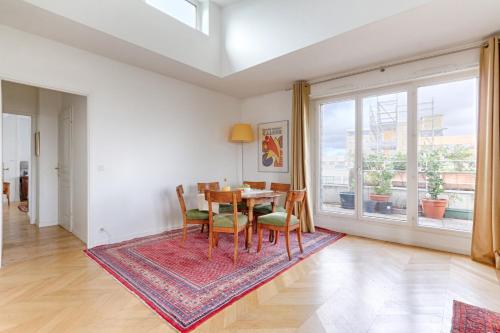 une salle à manger avec une table, des chaises et une grande fenêtre dans l'établissement Résidor - Apartment 4P La Villette Park, à Paris
