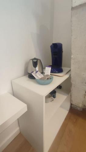 une table blanche avec un vase bleu sur elle dans l'établissement Appartements avec balcon au coeur des Chartrons, à Bordeaux