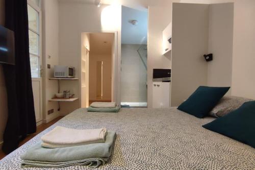 une chambre avec un grand lit avec deux oreillers dessus dans l'établissement Appartements avec balcon au coeur des Chartrons, à Bordeaux