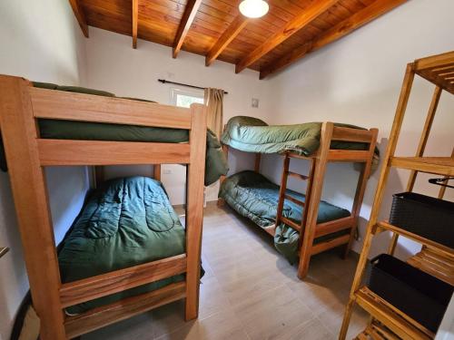 a room with three bunk beds in a house at La mansa del pinar in La Lucila del Mar