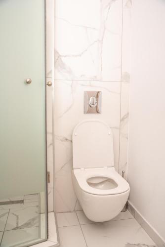 a white bathroom with a toilet and a shower at Sea & the City in Thessaloniki
