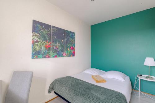 a bedroom with a bed and a painting on the wall at Le Souclin - Ma Cabotte in Lagnieu