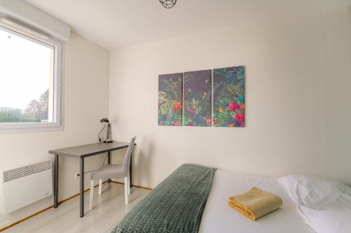 a bedroom with a bed and a desk and a painting at Le Souclin - Ma Cabotte in Lagnieu
