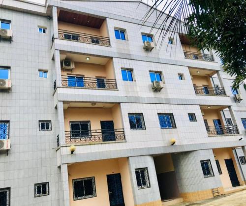un gran edificio blanco con ventanas y balcones en GMJ Résidence en Douala