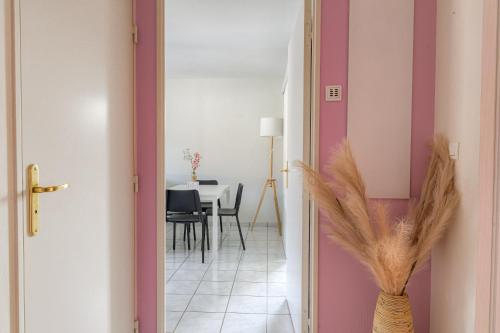 a hallway with a table and a vase with feathers at Le Souclin - Ma Cabotte in Lagnieu