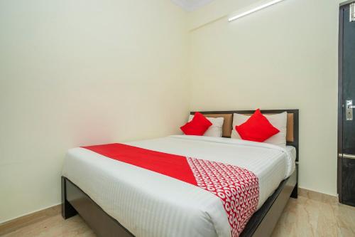 een slaapkamer met een groot bed met rode kussens bij 28119 Omkar Global Inn in Bangalore