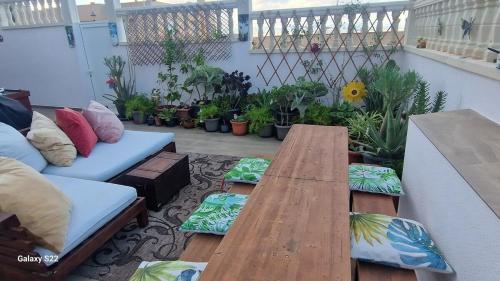 un patio con una mesa de madera y un sofá en Beach Life Carabassi Beach Gran Alacant, en Gran Alacant