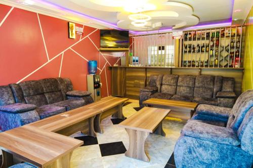 eine Bar mit Sofas, einem Tisch und Stühlen in der Unterkunft Gerly Homes in Kakamega