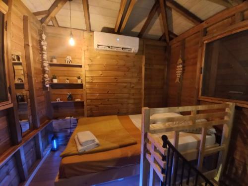 een kamer met een bed in een houten hut bij Cabane des Zamoureux in Ducos