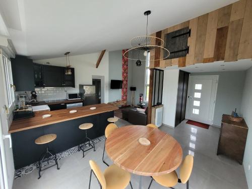 une cuisine et une salle à manger avec une table et des chaises en bois dans l'établissement Maison proche de Verdun, en campagne, jusqu'à 6 personnes, à Lemmes