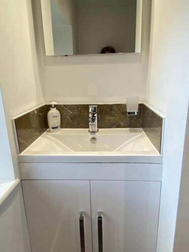 a bathroom with a sink and a mirror at The Byre @ Cow Close - Stay, Rest and Play in the Dales. in Leyburn