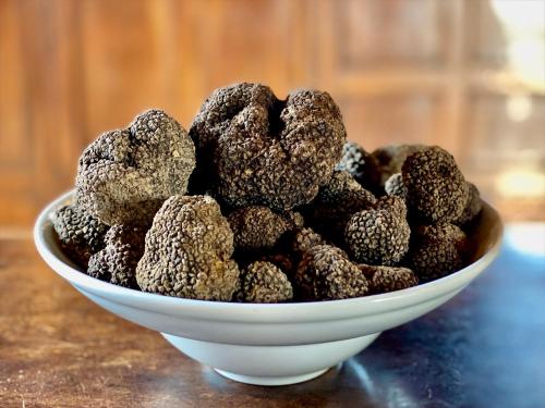 a white bowl of chocolate truffles on a table at Castello di Viano in Viano