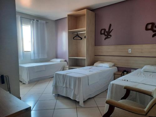 a hotel room with two beds and a window at Laras Hotel Ltda in Acailandia