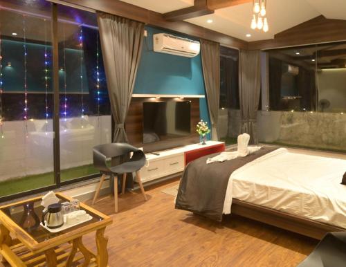 1 dormitorio con 1 cama, TV y silla en Hotel Limelight, en Kudāl