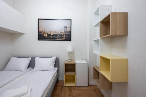 a bedroom with a bed and a picture on the wall at Krasiński Garden Apartments in Warsaw