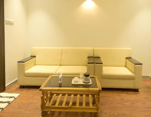 a living room with a couch and a coffee table at Hotel Limelight in Kudal