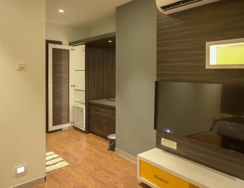 een woonkamer met een televisie en een badkamer bij Hotel Limelight in Kudāl