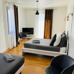 une chambre avec un grand lit et une chaise dans l'établissement Les Chambres de la bourse, à Pont-Saint-Esprit