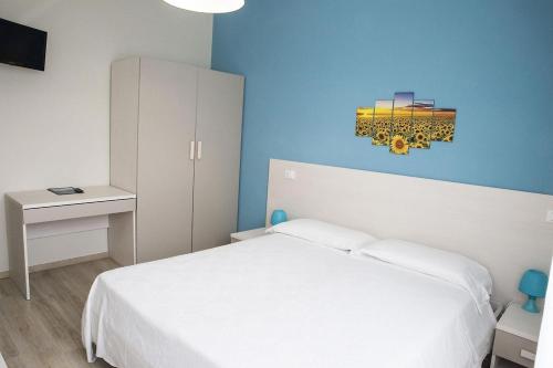 a bedroom with a white bed and a blue wall at Hotel Eden in Toscolano Maderno
