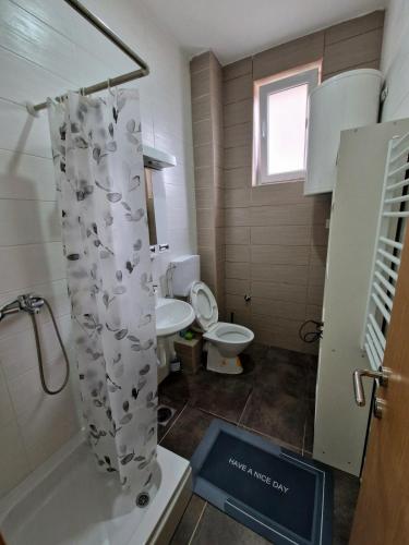 a bathroom with a toilet and a shower curtain at Tami in Belgrade