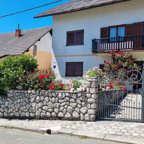 a house with a stone retaining wall and flowers at Holiday home in Lokve, Croatia 47707 in Lokve