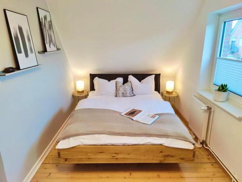 a bedroom with a bed with a book on it at Leni in Wesselburen