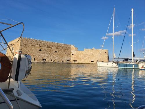 a boat in the water in front of a castle at Yacht ZEN in Heraklion