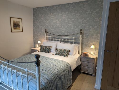 ein Schlafzimmer mit einem Bett und einer Wand mit Blumentapete in der Unterkunft Swan Cottage in Barnard Castle