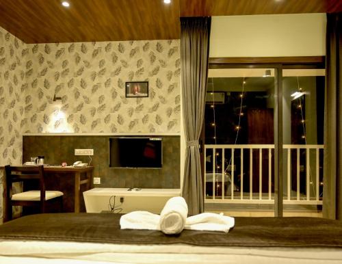 a bedroom with a bed with towels on it at Hotel Limelight in Kudal