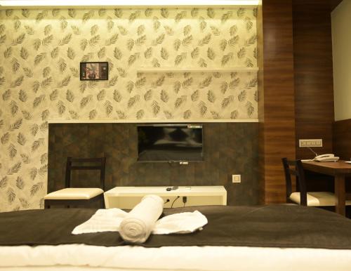 a bedroom with a bed and a sink and a mirror at Hotel Limelight in Kudal