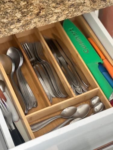 a drawer filled with silver utensils under a counter at Beira Mar Continental (mágica!) in Florianópolis